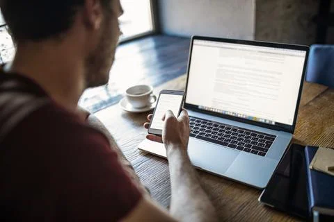 Man professional content writer using apps on contemporary cellphone during d Stock Photos