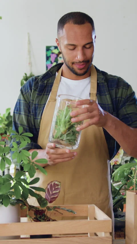 Man professional florists working at plants at flower shops. Hard work in greenh Stock Footage 334440910