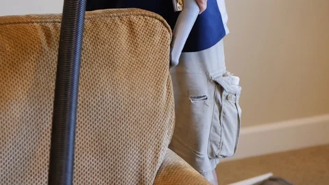 Man professionally cleans the back cushion of a green cloth couch Stockbeeldmateriaal 85865322