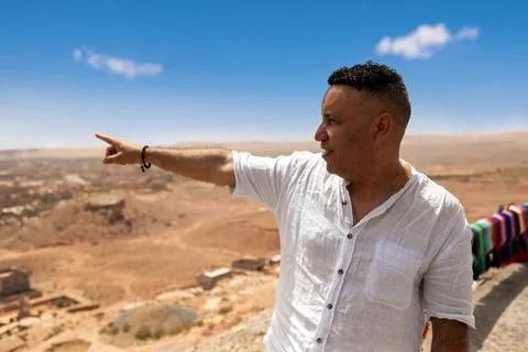 Man in profile pointing at the panoramic view of the oasis in Tinghir. 库存照片