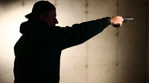 MAN IN PROFILE USES ONE HAND TO FIRE GUN Stock Footage 58130473