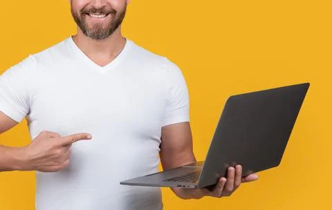 Man programmer pointing finger on laptop isolated on yellow background. man Stock Photos