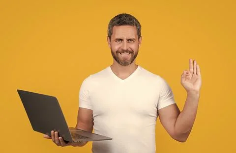 Man programmer work on laptop with ok gesture. man programmer work online. man Stock Photos