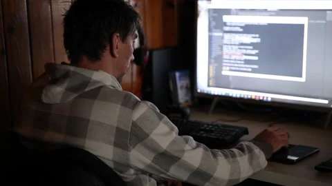 Man programmer working on computer at home coding on screen writing code Stock Footage 141430187