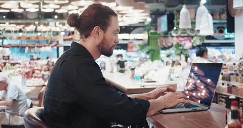 Man programmer working at laptop computer at city cafe. Male professional IT or Stock Footage 256914804