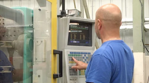 Man programming CNC controller on machinery Stock Footage 46630483