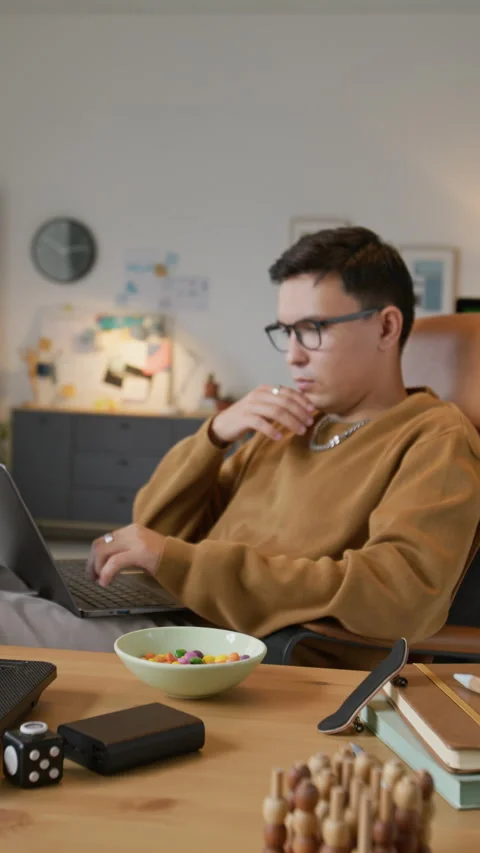 Man Programming on Laptop and Eating Candy Stock Footage 317344623