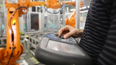 Man programming robot in automotive industrial, professional programmer Stock Footage 124189842