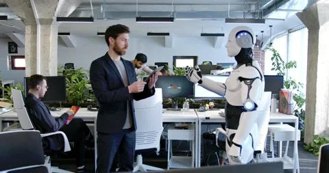 Man programming robot with tablet computer in hands in office. Male developer Stock Footage 180034733