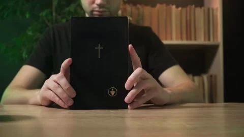 A man is promoting Christianity, a guy is holding a book of the New Testament Stock Footage 264131079