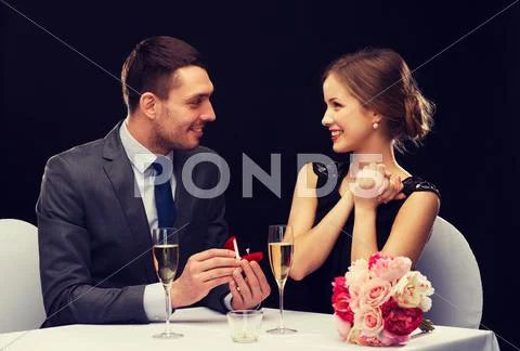 Man proposing to his girlfriend at restaurant Stock Photos