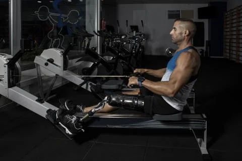 Man with prosthesis training on exercise machine Stock Photos