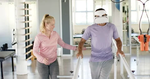 Man in prosthetic leg using VR headset with therapist on parallel bars Stock-Footage 300148195