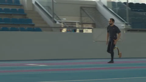 Man with Prosthetic Limb Falling Off while Doing Long Jump on Track Stockbeeldmateriaal 259284852