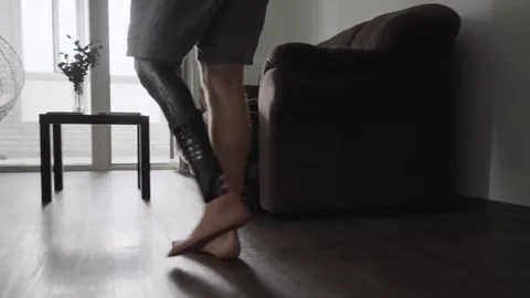Man with Prosthetic Limb Sits Down and Opens Laptop at Home Stock Footage 317900966