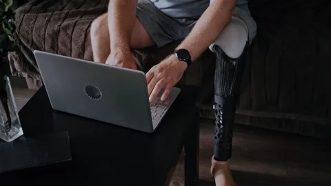 Man with Prosthetic Limb Working from Home on Laptop in Morning Stock-Footage 317974426