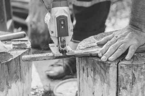 Man with protection gloves using an electric saw Stock Photos