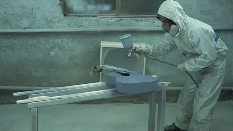 Man in a protective coverall applies a layer of gray on the guitar with a tools Stock-Footage 74021834