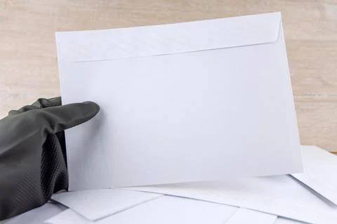 Man with protective gloves examines anonymous envelopes Stock Photos