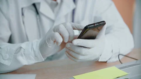 A man in protective gloves on his hands is typing a text using a mobile phone. Video stock 146263359