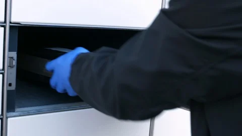 Man in protective gloves opening box in parcel locker taking package close Stock Footage 128879297