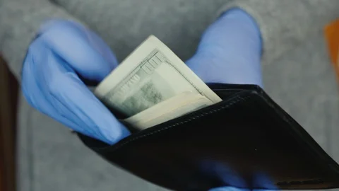 Man in protective gloves pulls money out of wallet Stock Footage 129333351