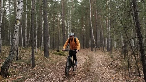 Man in a protective helmet with a backpack rides a mountain bike Stock Footage 253983864
