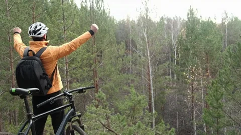 Man in a protective helmet  climbed a mountain bike and celebrates Stock Footage 253983770