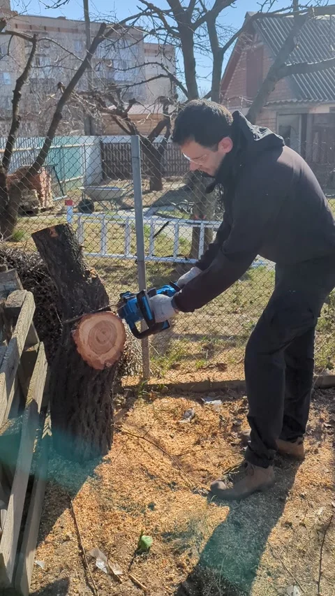 Man in a protective mask with a chainsaw in his hands Stock Footage 267690156