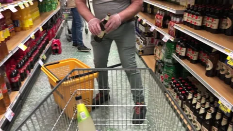 Man in a protective mask choosing alcohol Stock Footage 130247021
