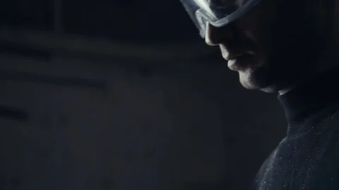 Man in a protective mask on a dark background working on electric tool Video stock 73015768