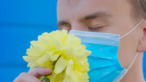 The man in the protective mask does not smell the flower Stock Footage 141381382