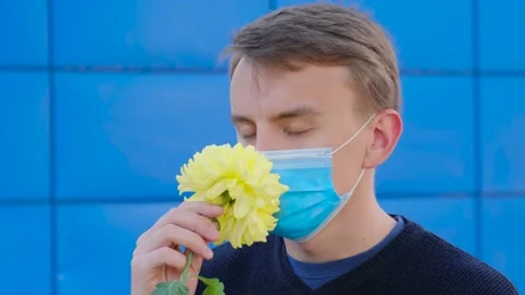 The man in the protective mask does not smell the flower Video stock 142091986