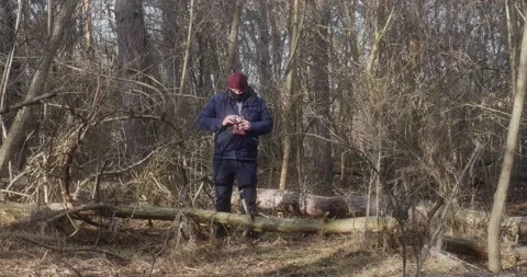 A man in a protective mask in the forest takes pictures with an old film cam Vídeos de archivo 166439340