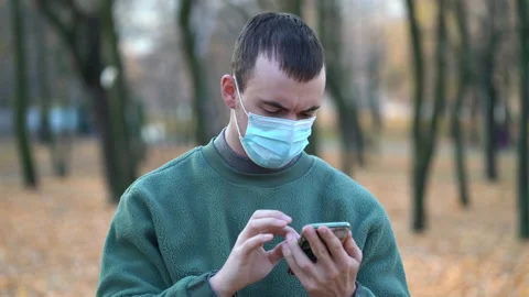 Man in a protective mask on his face used smartphone Stock Footage 143778408