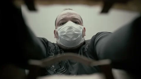 A man in a protective mask opens a paper delivery bag from an online store. Video stock 196828833