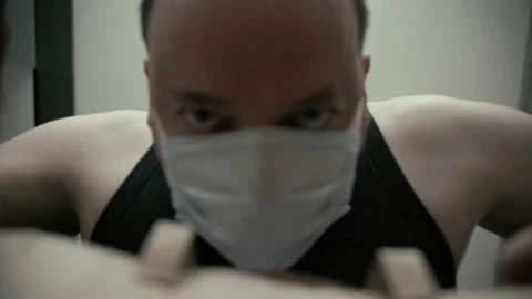 A man in a protective mask opens a paper delivery bag from an online store. Video stock 196828846