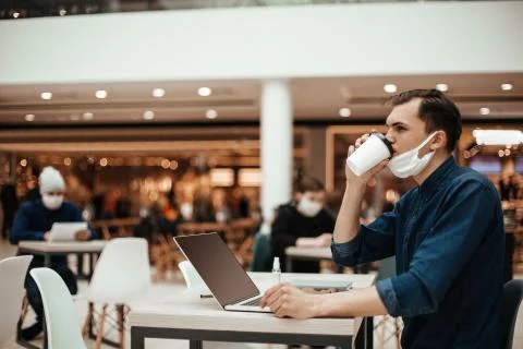 Man in a protective mask sitting at a table in a cafe Foto stock