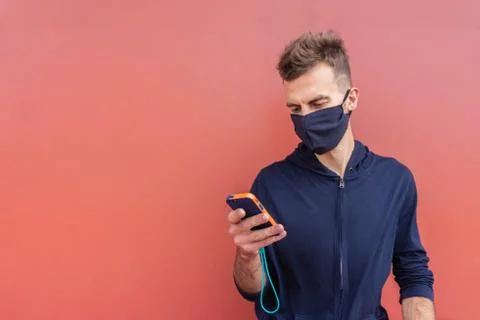 Man with protective mask using mobile phone Stock Photos