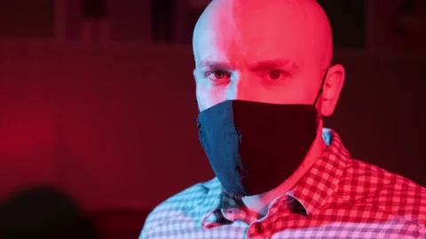 Man with protective medical mask,looking at camera, flashing red, blue light. Stock Footage 152845385