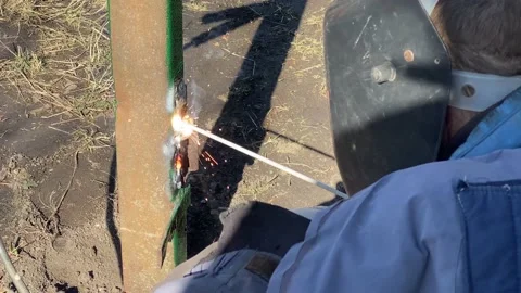 Man in protective shield and gloves welds steel structure Stock Footage 177970828