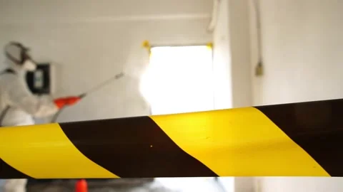 Man in protective suit and face mask spraying for disinfection in the office Stock Footage 148098430