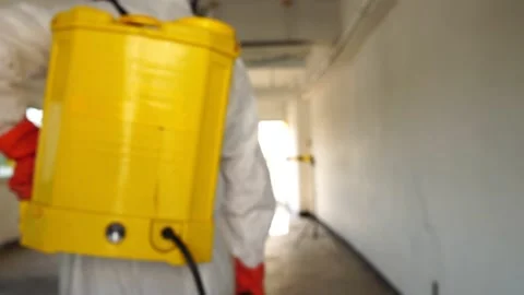 Man in protective suit and face mask spraying for disinfection in the office 库存影片 148098531