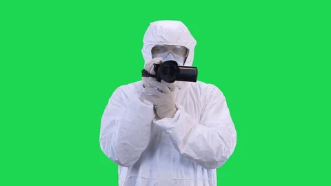 A man in a protective suit and goggles is slow motion video recording on a video Stock Footage 128756949