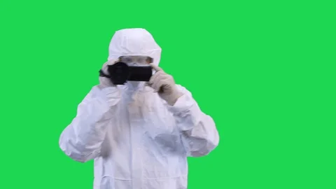A man in a protective suit and goggles is filming a video camera with his hands Stock Footage 129042214