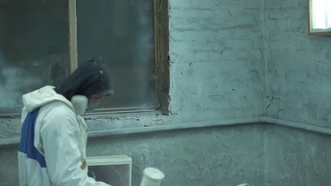 Man in protective suit atomizes paint layer on a guitar Stock Footage 73910244