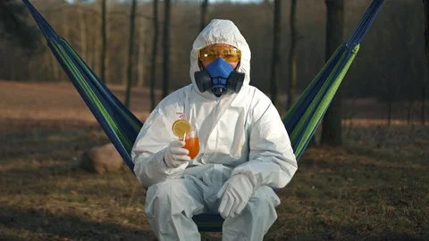 A man in a protective suit is lying on a hammock. Stock Footage 127247473