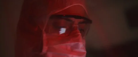 Man in protective suit with mask and glasses, scrolling through the cellphone Stock Footage 126357715