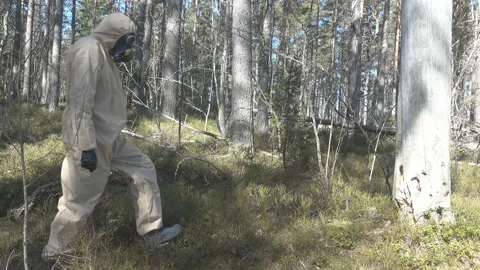 Man in protective suit, mask in forest Stock Footage 130978424
