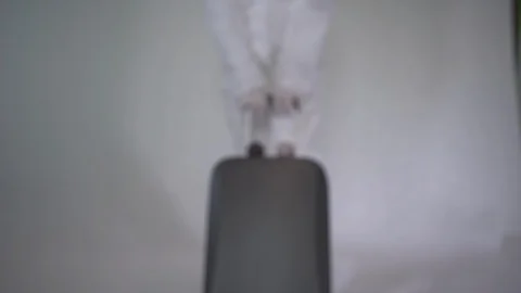 A man in a protective suit pulls a suitcase with coronaviruses, staging Stock Footage 126912290